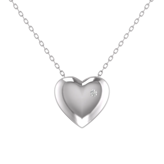 A polished silver heart pendant necklace with a small clear gemstone accent, suspended from a delicate silver chain against a plain white background.