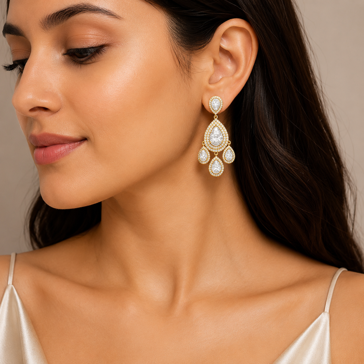 A close-up of a woman wearing a gold and white beaded dangle earring, shown from the side against a neutral beige background.