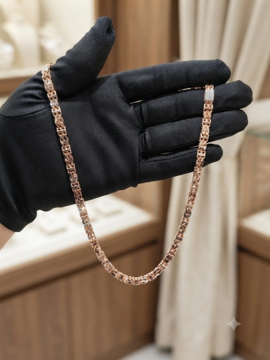 A close-up of a rose gold chain necklace draped over a hand wearing a black glove, set against a softly blurred jewelry store background.